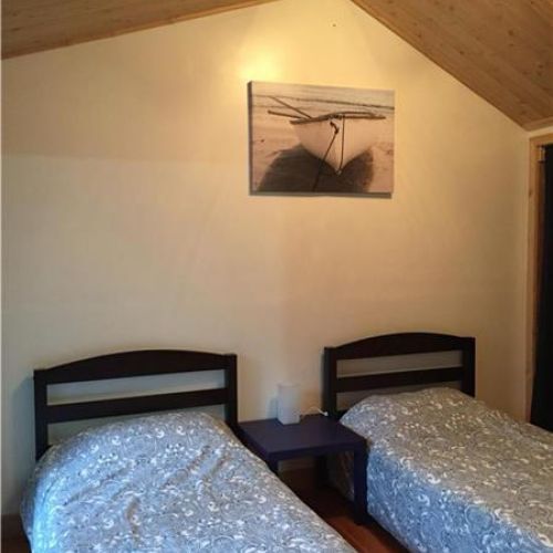 Bedroom 2: Cozy twin bedroom, ideal for kids or friends, with a warm and inviting cottage feel.