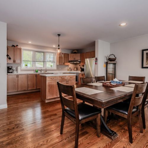 An open-concept dining area flows seamlessly into the fully-equipped kitchen, perfect for gathering with friends and family.