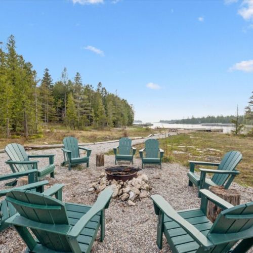 Gather around the outdoor firepit area for cozy evenings under the stars by the peaceful shoreline.