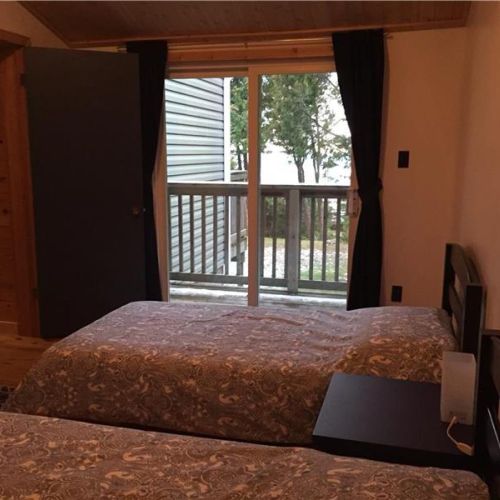 Bedroom 2: Private bedroom with direct walkout to the balcony—enjoy fresh air and lake views anytime.