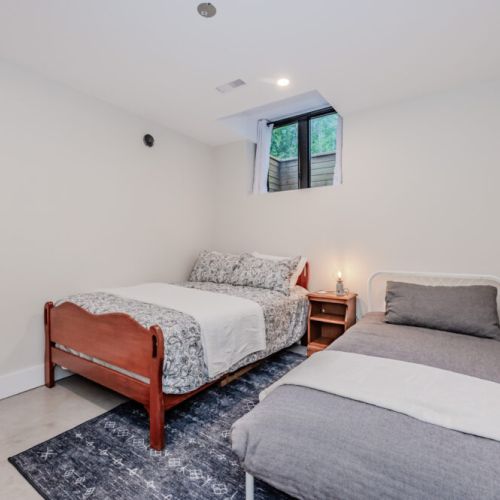 This cozy vacation rental bedroom offers a peaceful retreat with a double and twin bed—perfect for families or friends. Enjoy restful nights after your day of exploring, hiking, or lake adventures in this tranquil escape.
