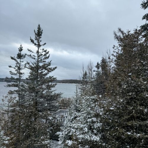 Enjoy serene winter mornings with sparkling lake views from the comfort of your snowy deck at this peaceful vacation rental escape.