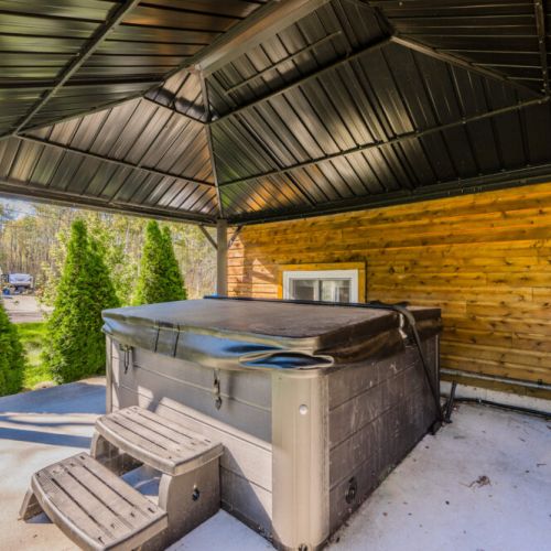 The relaxing hot tub, nestled under a sheltered gazebo, offers the perfect spot to unwind after a day of exploring. Whether enjoying a quiet evening under the stars or warming up during cooler months, the hot tub area provides a private oasis for relaxation.