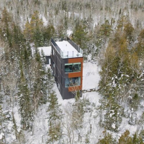 A modern treetop retreat perched high in the forest, offering privacy, design-forward comfort, and a peaceful Bruce Peninsula escape in every season.
