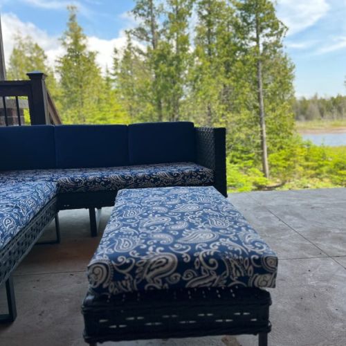 Covered patio with comfortable outdoor seating and tranquil views of the water