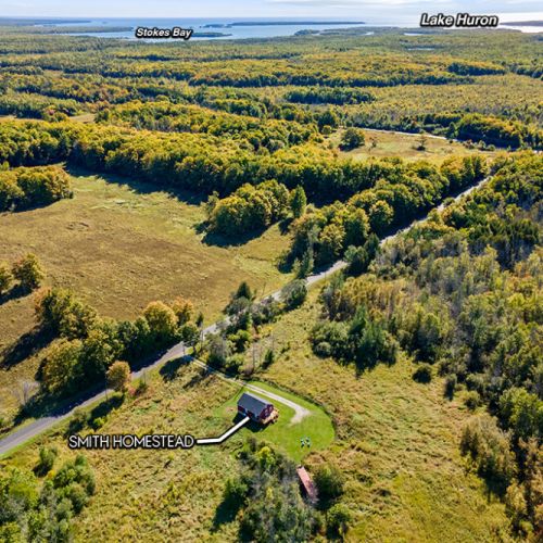 From above, see just how close Smith Homestead is to the natural beauty of Ira Lake, with Lake Huron and Stokes Bay in the distance.