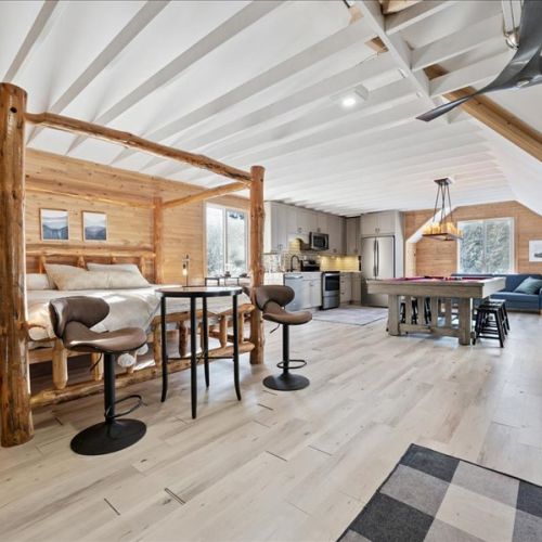 Bright open loft layout with a cozy bed, seating, and room to unwind. Perfect for longer stays with space to work, relax, and enjoy time indoors.