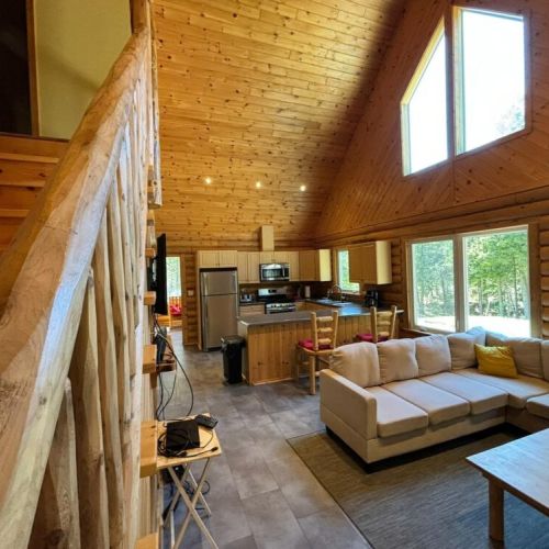 The Great room with easy access to the upper sleeping area and lower kitchen with eating island. The main staircase leads to an upper main bathroom and two bedrooms. The kids love yelling from the upper landing in the morning!