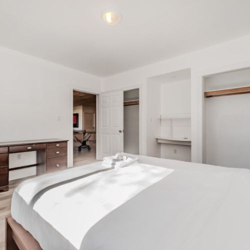 Spacious, sunlit bedroom with fresh linens, large closets, and a built-in desk—ideal for extended stays, remote work, or a peaceful retreat near the lake.