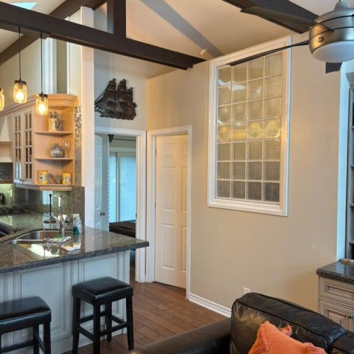 An open-concept living and kitchen space with warm finishes and natural light. Designed for gathering, entertaining, and comfortable vacation living.