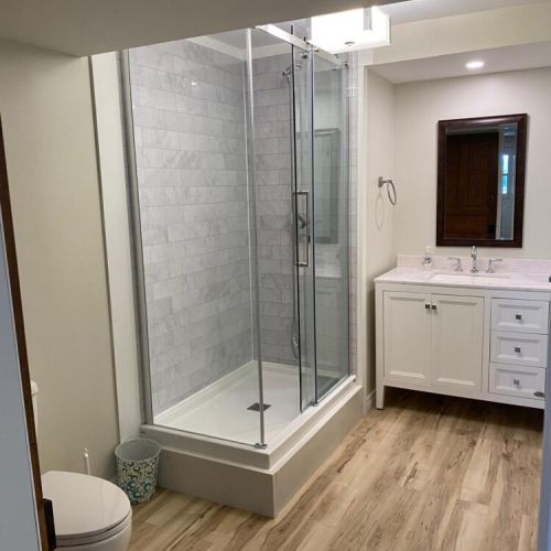 The updated bathroom features a modern glass shower and plenty of space to refresh in comfort.