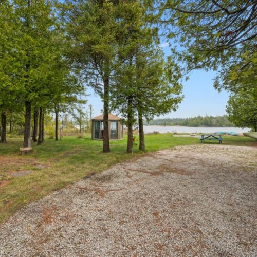 Nestled among mature trees, the property offers a peaceful retreat with direct waterfront access.