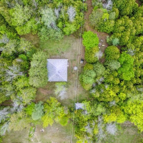 This direct overhead view showcases Chief’s Cottage nestled among dense cedar and maple trees. The lush forest canopy creates a natural buffer from the road, ensuring guests enjoy peace, seclusion, and a full immersion in nature.