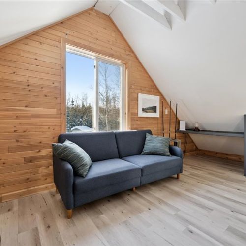 Cozy loft lounge area with a comfortable couch and warm wood finishes. A perfect place to read, watch a movie, or enjoy a quiet afternoon in.