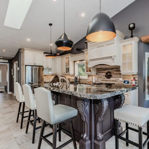 Stunning kitchen with granite island, custom cabinetry, and designer lighting. This vacation rental offers a luxurious space to cook, entertain, and unwind in style.