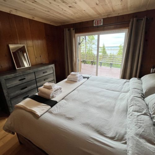 The master bedroom has direct access to the balcony overlooking the lush surroundings, blending indoor comfort with outdoor beauty.