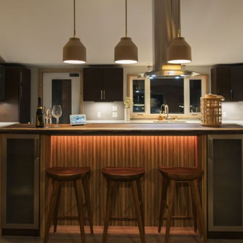 Gather around the kitchen island and enjoy the warm glow of the pendant lights. This inviting space is perfect for enjoying a glass of wine and catching up with loved ones.