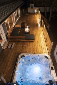 Evenings on the deck: Enjoy a bubbling hot tub, cosy lounge seating, and a glowing fire table—all brought together by warm deck lighting.