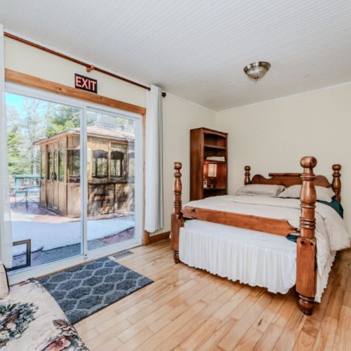 Wake up to nature views with walkout access to the deck and hot tub. A peaceful bedroom retreat for restful nights at your private vacation rental.
