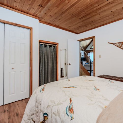 Spacious bedroom with rustic wood accents, ample closet space, and cozy decor — a welcoming retreat for your lakeside getaway.