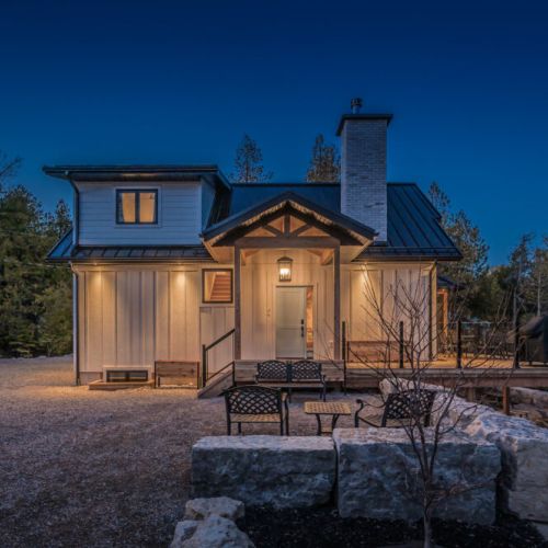 Charming lakeside cottage with ambient lighting and cozy outdoor seating. A serene escape perfect for starlit evenings, weekend getaways, and family retreats in cottage country.