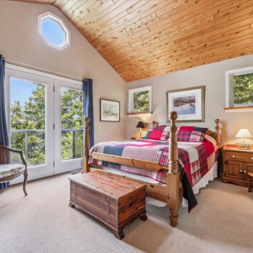 Wake up to forest views and step out onto your private balcony in the airy, vaulted-ceiling primary bedroom.