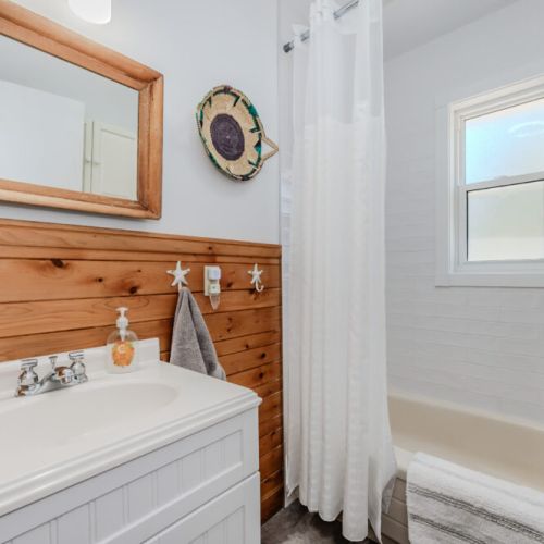Rustic-chic bathroom with a blend of modern touches and cozy cottage style, ideal for freshening up after a day of outdoor adventure.