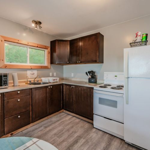 The kitchen includes all essentials, from a microwave to a full-size refrigerator and stove, ready for home-cooked meals.