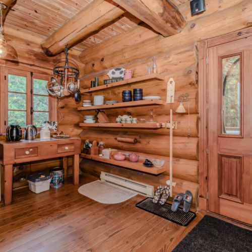 A welcoming entryway features built-in shelving and warm wood finishes, providing a functional yet inviting space to store essentials and prepare for outdoor adventures.