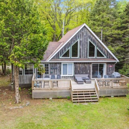 Gaze at the treetops or the lake from the impressive window-lined A-frame facade—designed to bring the beauty of the outdoors right into the living space.