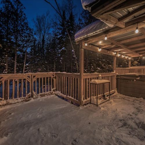 Your private hot tub area with string lights and snowy forest views. The perfect way to relax and warm up after a day exploring the Peninsula.