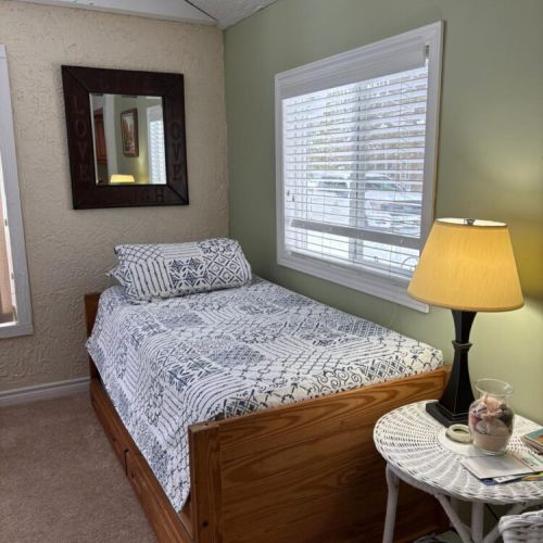 Simple, cozy bedroom with a comfortable bed and warm lighting for a restful sleep.