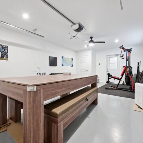 A spacious recreation area with pool table and fitness equipment, perfect for friendly competition or staying active during your stay.