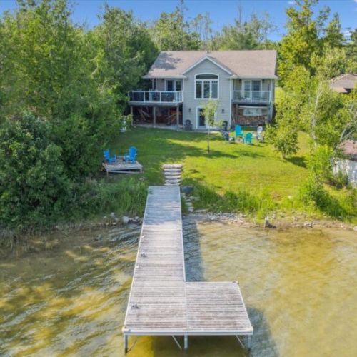 Private lakeside retreat with spacious yard, multiple seating areas, and your own dock—perfect for relaxing days by the water.