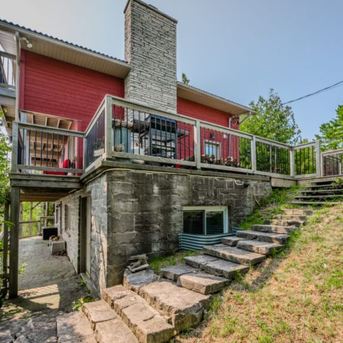 The charming stone steps lead you through the beautifully landscaped property, adding to the cottage's rustic appeal. It's a delightful blend of natural and crafted elements.