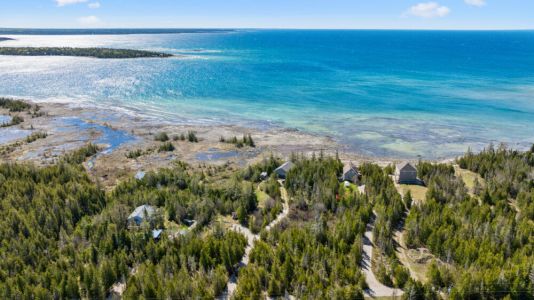 Crystal-clear waters and rugged Lake Huron shoreline surrounding Changing Shores.