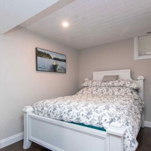 Cozy lower-level bedroom with a comfortable queen bed for restful nights.