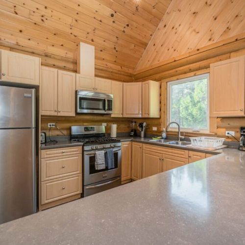 A fully equipped kitchen with modern amenities awaits in the kitchen, where guests can cook and converse in a space that feels like home.