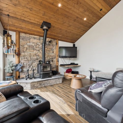 Gather in the cozy living room, perfect for shared meals, or curling up with a good book. The inviting family room, with its warm wood tones, offers a relaxing space for everyone to unwind with a wood burning stove. From Nov-April only.