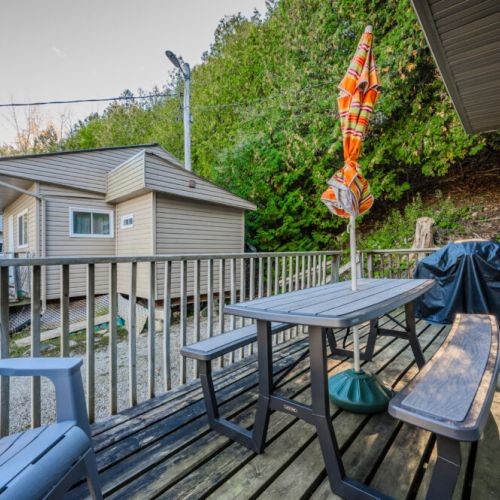 The cabin’s private deck includes a BBQ grill and seating area, ideal for outdoor cooking and gathering.