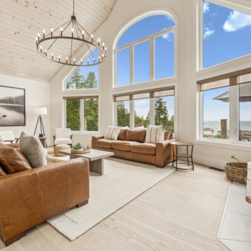 Relax in a spacious great room with soaring ceilings and panoramic lake views—your perfect cozy escape after a day of adventure.