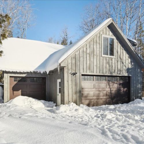 Exterior view of the loft suite above the heated garage, surrounded by fresh snow. A private, cozy retreat with a true Bruce Peninsula feel.
