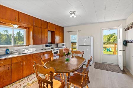 Enjoy meals together around the dining table, surrounded by the warm character of this classic country kitchen.
