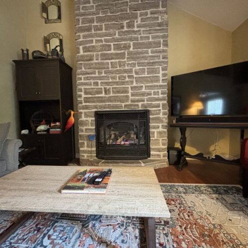 Comfortable Living: This cozy corner in The Louise’s living room is a blend of comfort and convenience. Snuggle up on the couch with a good book or enjoy your favorite show on the flat-screen TV, conveniently placed beside the warmth of a stone fireplace, making this the ideal spot for relaxation and entertainment.