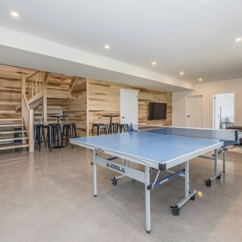 Professional table tennis table in the spacious games space, with couches in the corner lounge perfect for relaxing conversation or waiting for the next game.