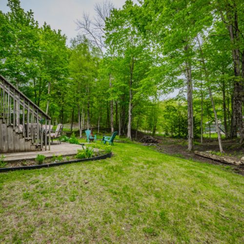 Enjoy the fresh forest air on the spacious wooden deck, perfect for morning coffee or evening gatherings around the fire pit with friends and family.