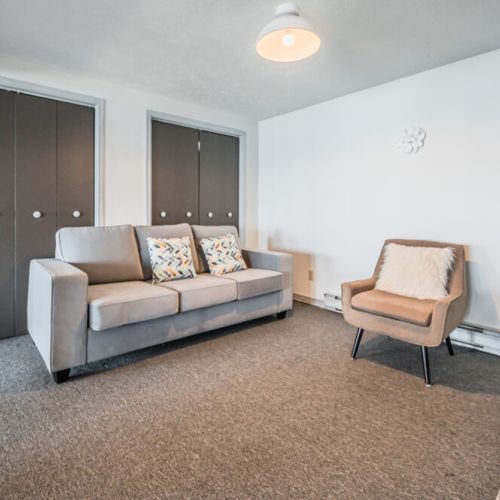 The cozy lower level living room with a comfortable sofa, perfect for additional family members or friends.