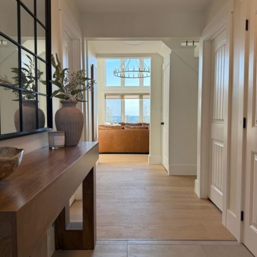 Natural light floods the hallway, guiding you to a sun-soaked living area with incredible lake views.