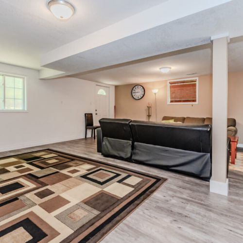 This large, open basement area is great for gatherings, offering plenty of seating and space to move around."