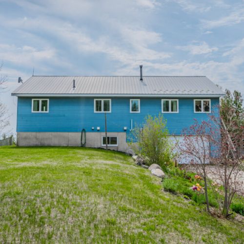 Spacious backyard with a clear view of the cottage and open green space—great for kids to play or families to relax outdoors.